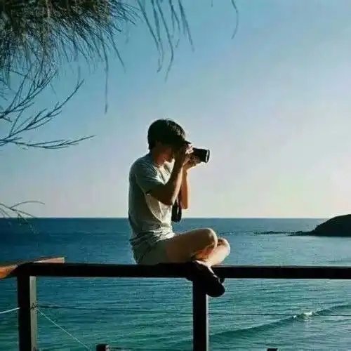 一个男的坐在红椅子上,背影,面对海边头像