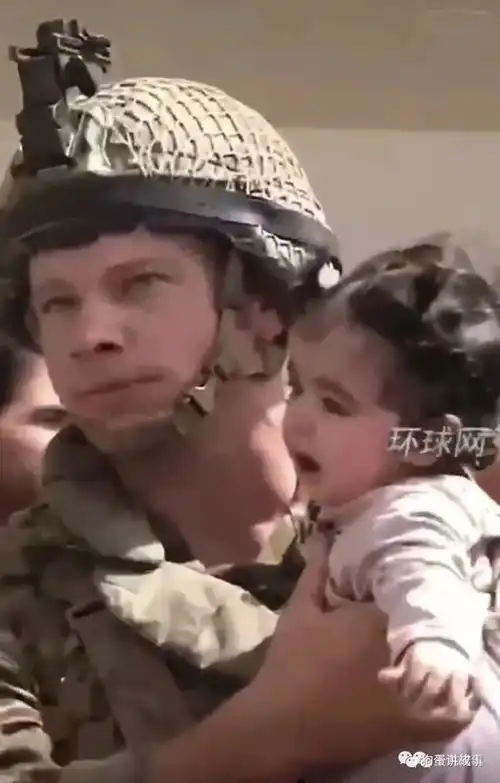 绝望的阿富汗父亲将手中婴儿高高举过围墙,递送给美国大兵求带走