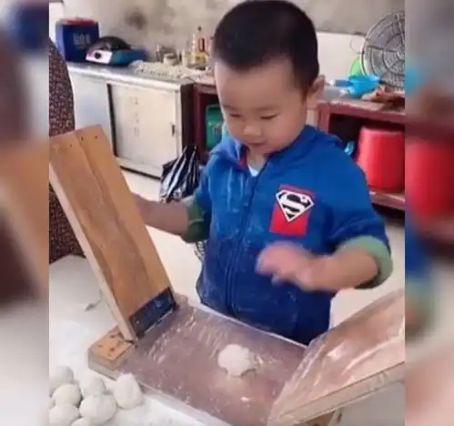 萌娃帮奶奶压面皮儿获高赞,网友这小工具不错,要啥擀面杖