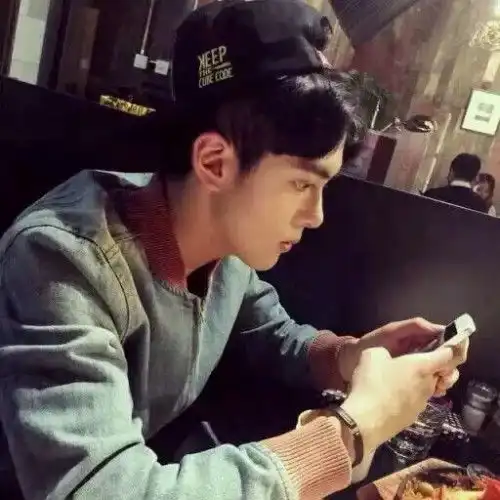 情侣头像男的低着头穿着白衣服拿着黑色手机